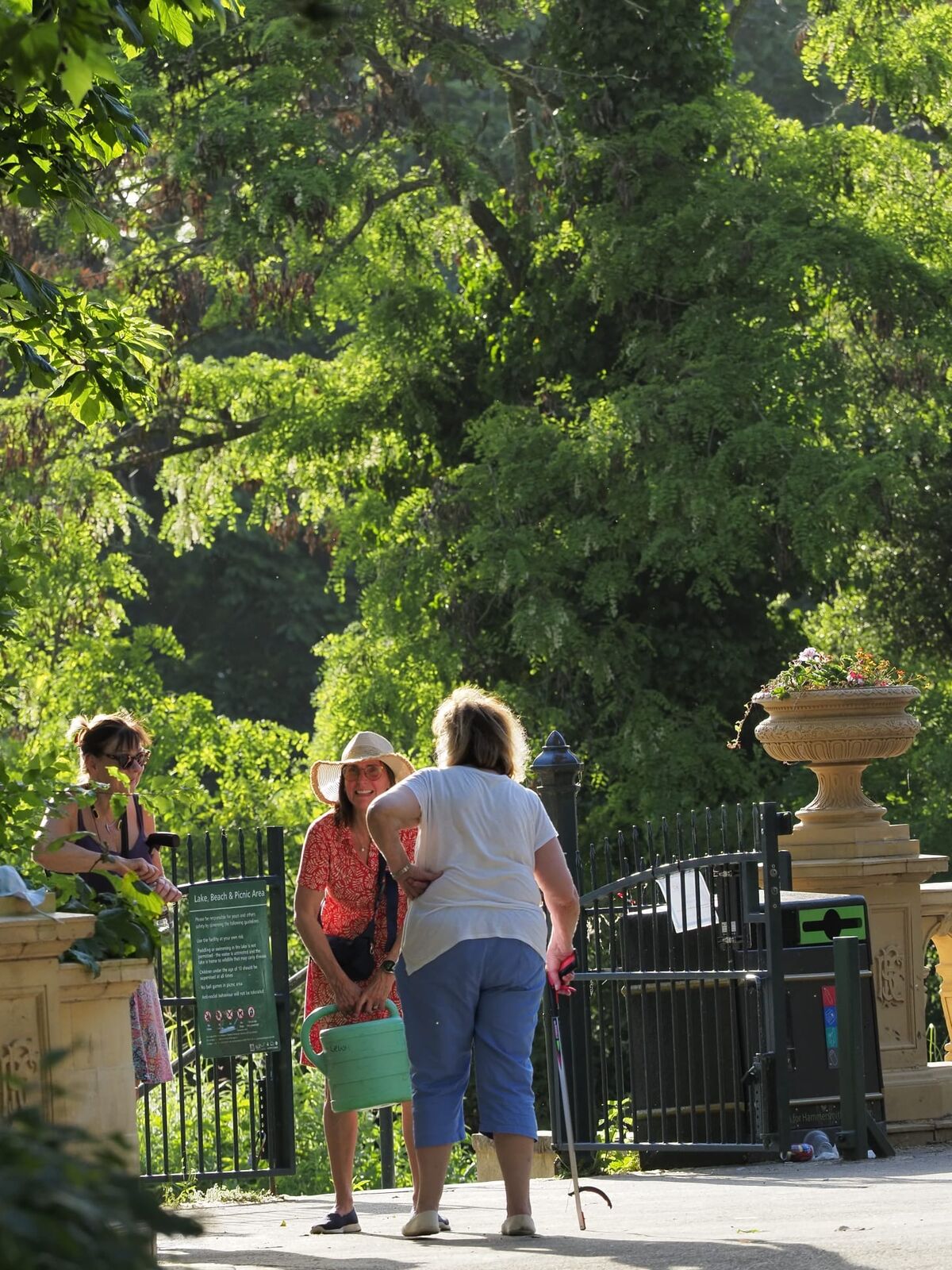 Walkers by the old garden gate and sculptures